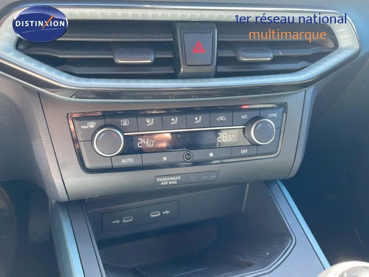 Vue rapprochée de la console centrale du SEAT Arona 2025, avec commandes climatisation et ports USB visibles.