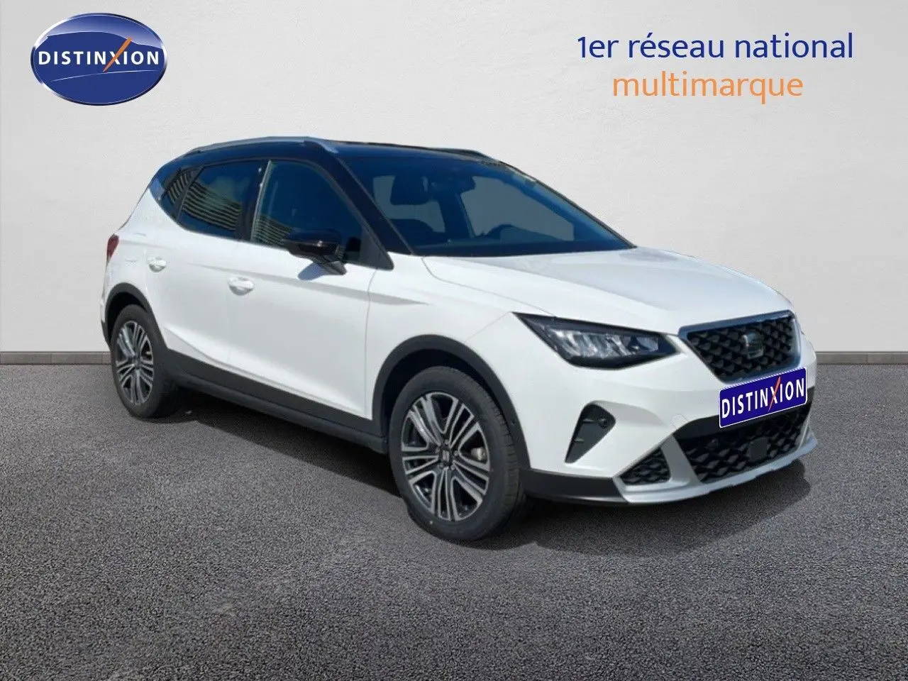 SEAT Arona 2025 blanc avec toit noir en vue 3/4 avant droit, mettant en valeur ses optiques LED et jantes alliage.