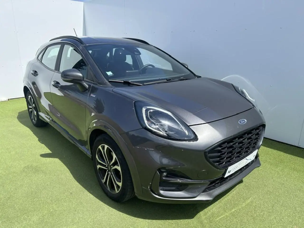 Ford Puma gris Magnetic en vue 3/4 avant droit avec calandre noire et jantes alliage 17 pouces.