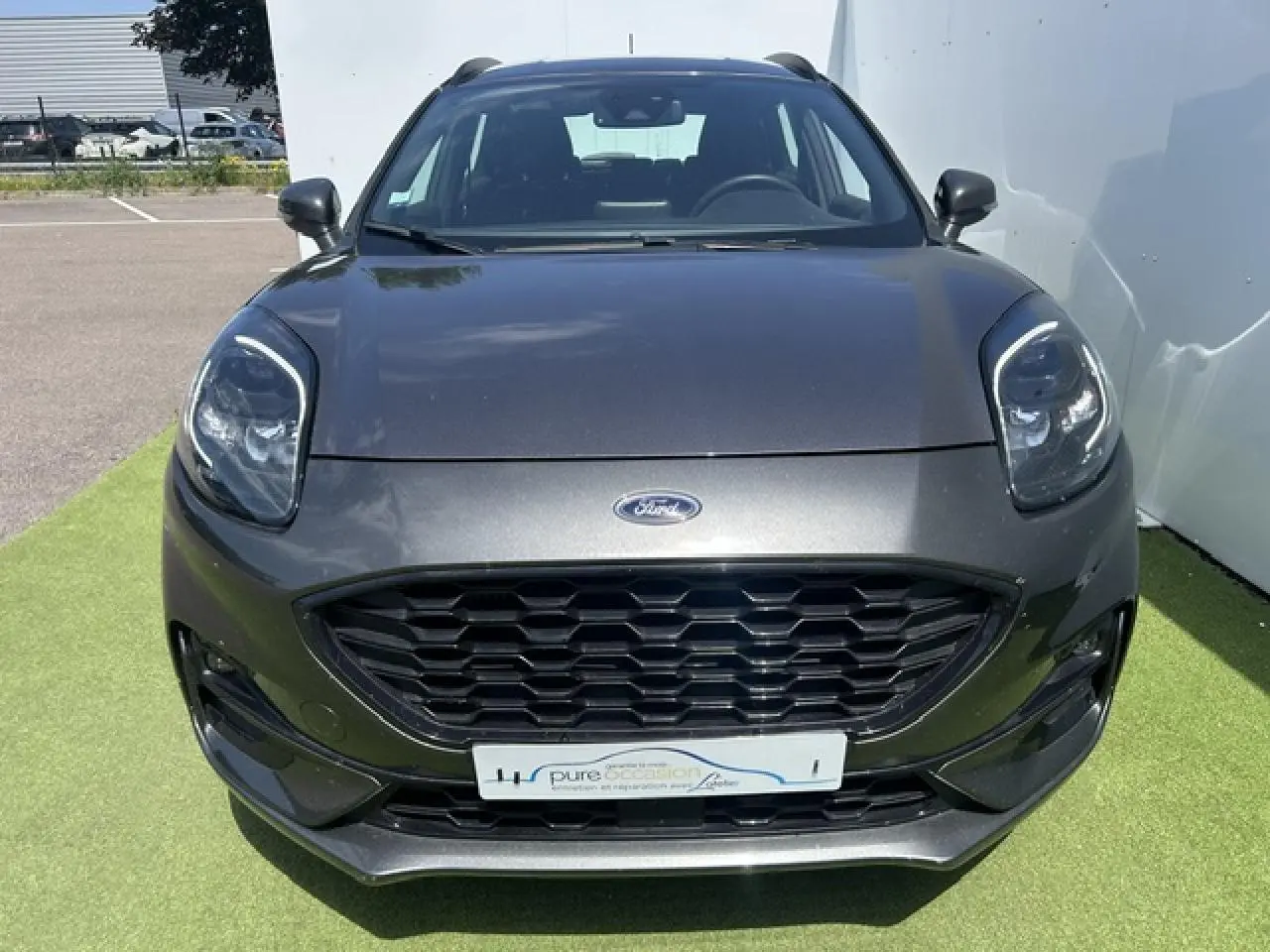 Vue avant d'un Ford Puma gris magnetic avec calandre noire hexagonale et phares LED distinctifs.