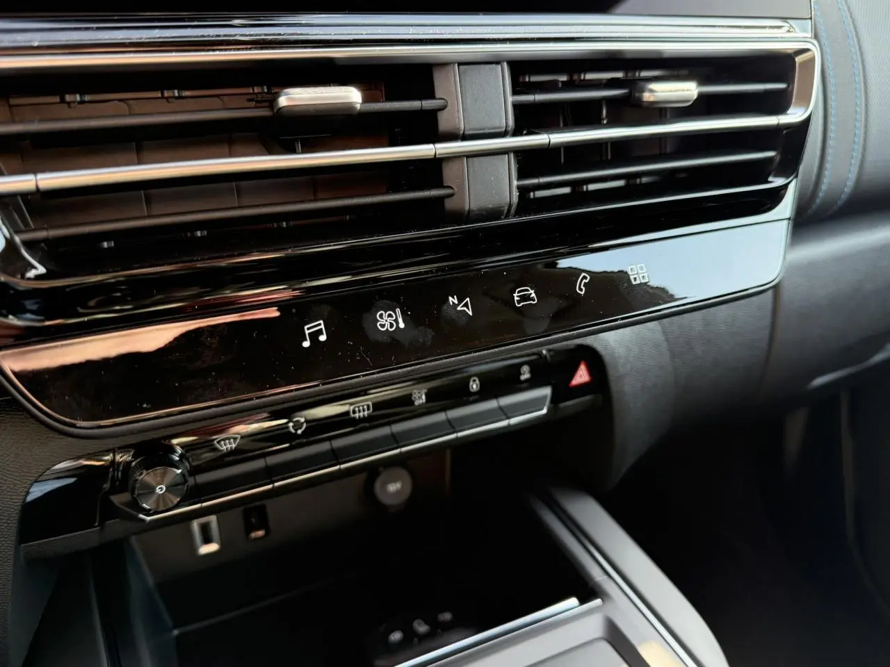 Détail de la console centrale noire brillante du Citroën C5 Aircross 2025, avec commandes tactiles et aérateurs horizontaux.