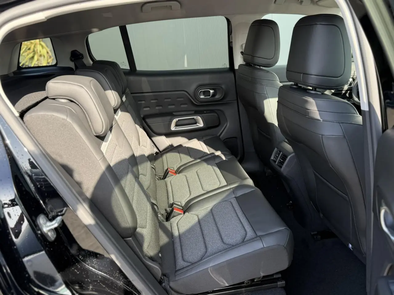 Vue intérieure côté gauche des sièges arrière en tissu gris et cuir noir du Citroën C5 Aircross noir Perla 2025.