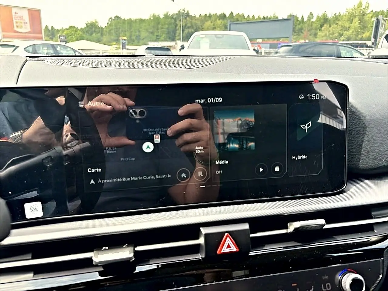 Écran tactile central du Kia Sportage 1.6 hybride 239 gris eclipse, affichant la navigation et mode hybride.
