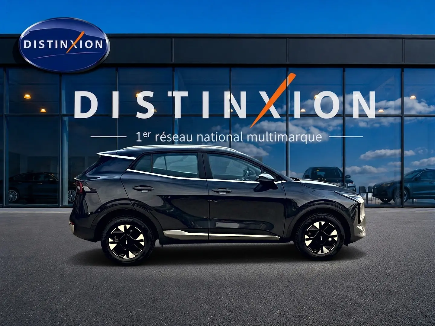 Vue de profil côté gauche du KIA SPORTAGE 1.6 hybride 239 Active gris eclipse, avec jantes alu et barres de toit visibles.