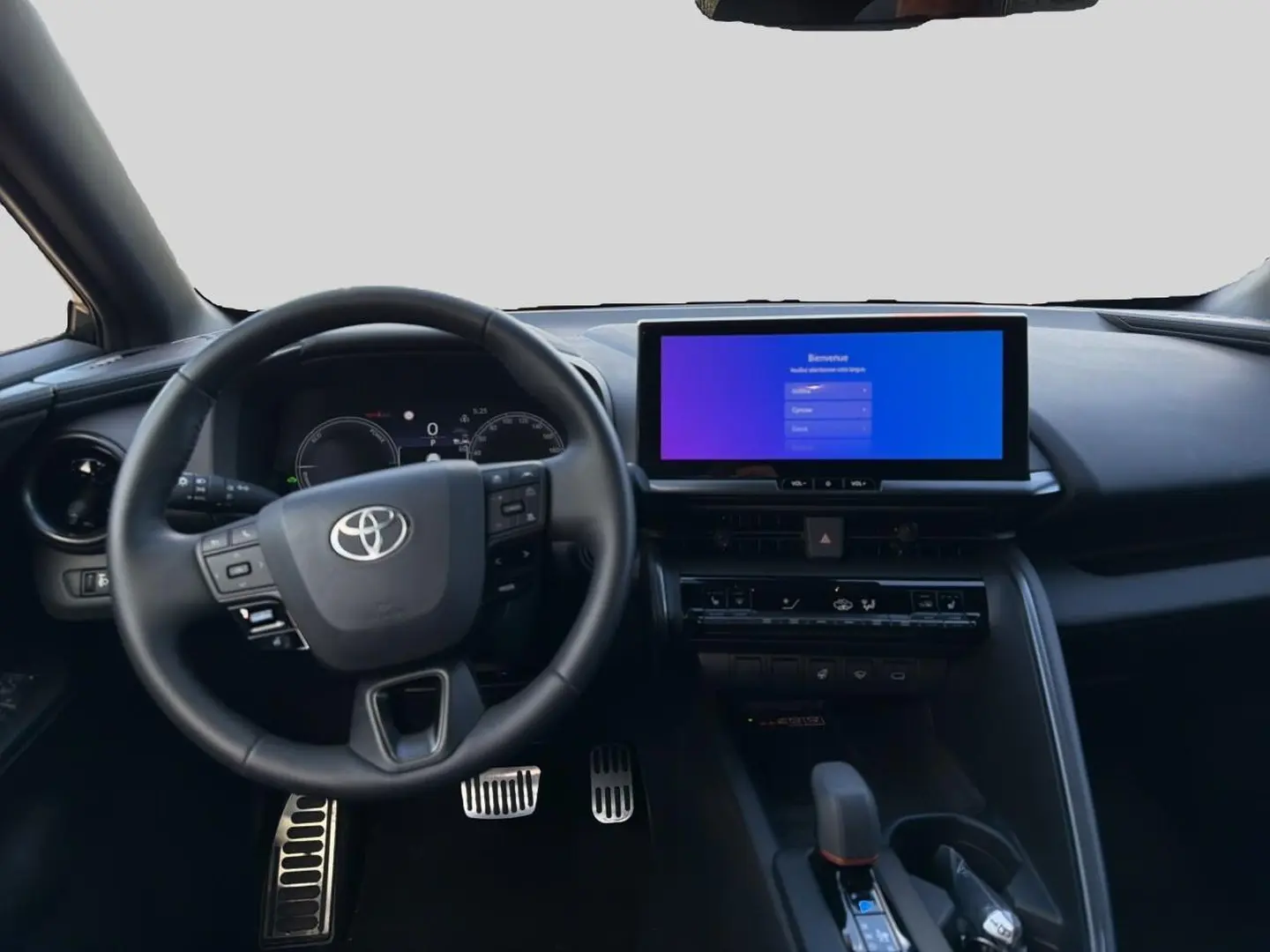 Vue intérieure frontale du tableau de bord noir du Toyota C-HR 1.8 hybride 2025 avec écran tactile large et volant multifonction.