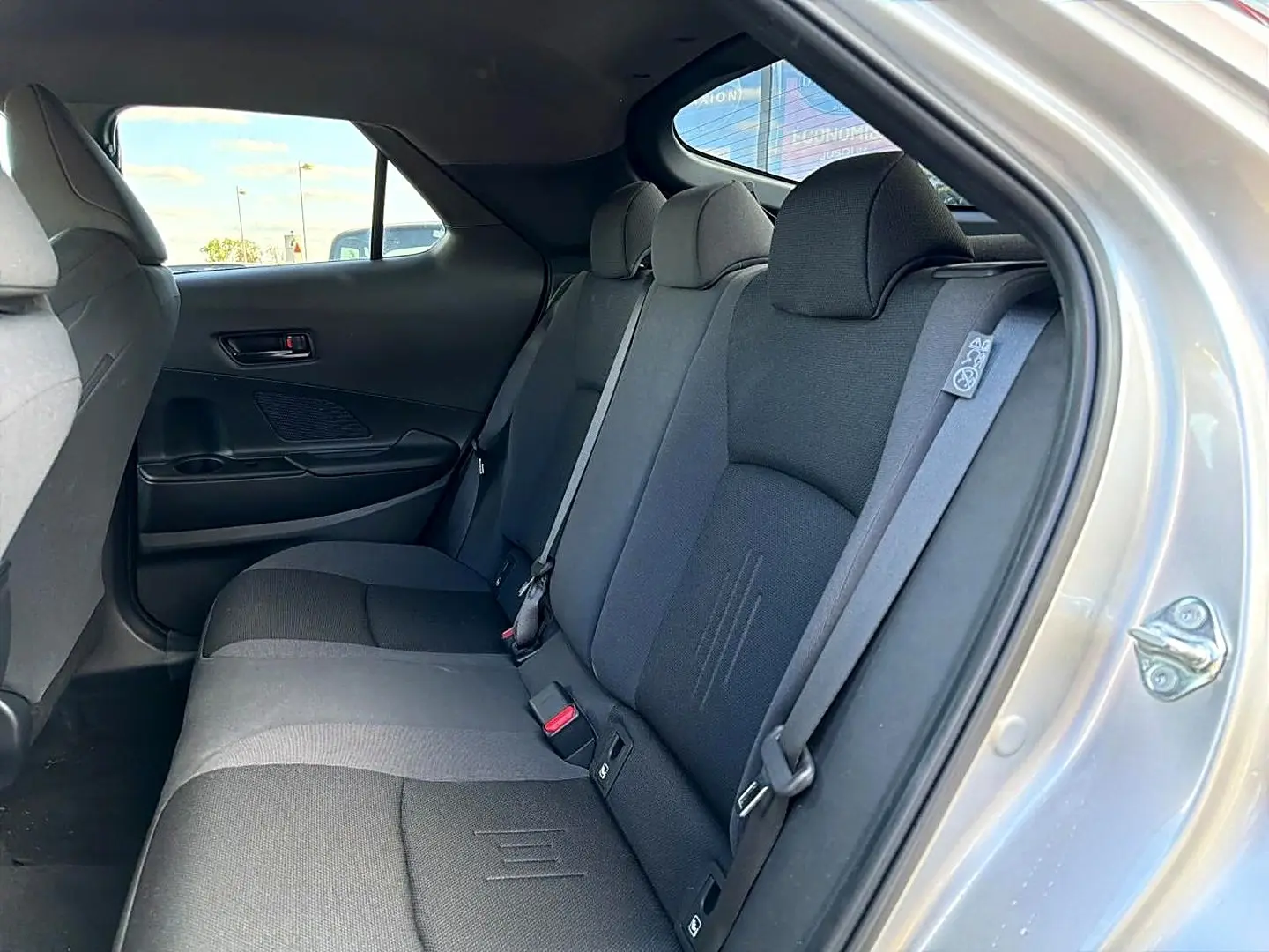 Vue intérieure côté droit sur la banquette arrière gris foncé du Toyota C-HR 1.8 hybride 2025 avec ceinture de sécurité visible.