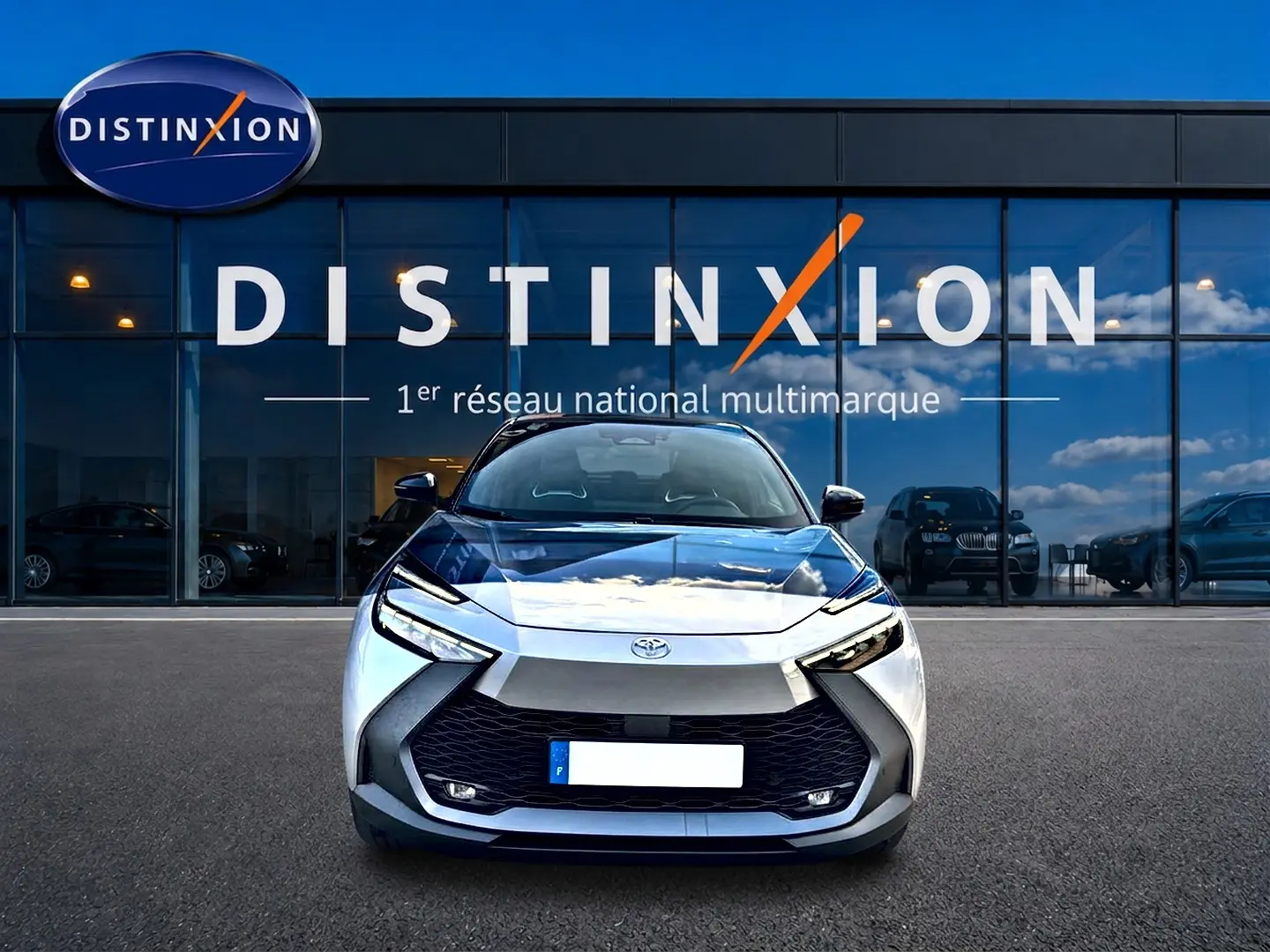 Vue frontale d'un Toyota C-HR 1.8 hybride gris 2025 avec calandre noire et phares LED distinctifs.