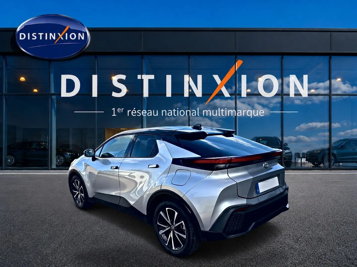 Vue 3/4 arrière droite du Toyota C-HR 1.8 hybride gris métallisé, avec feux arrière LED et jantes alliage noires.