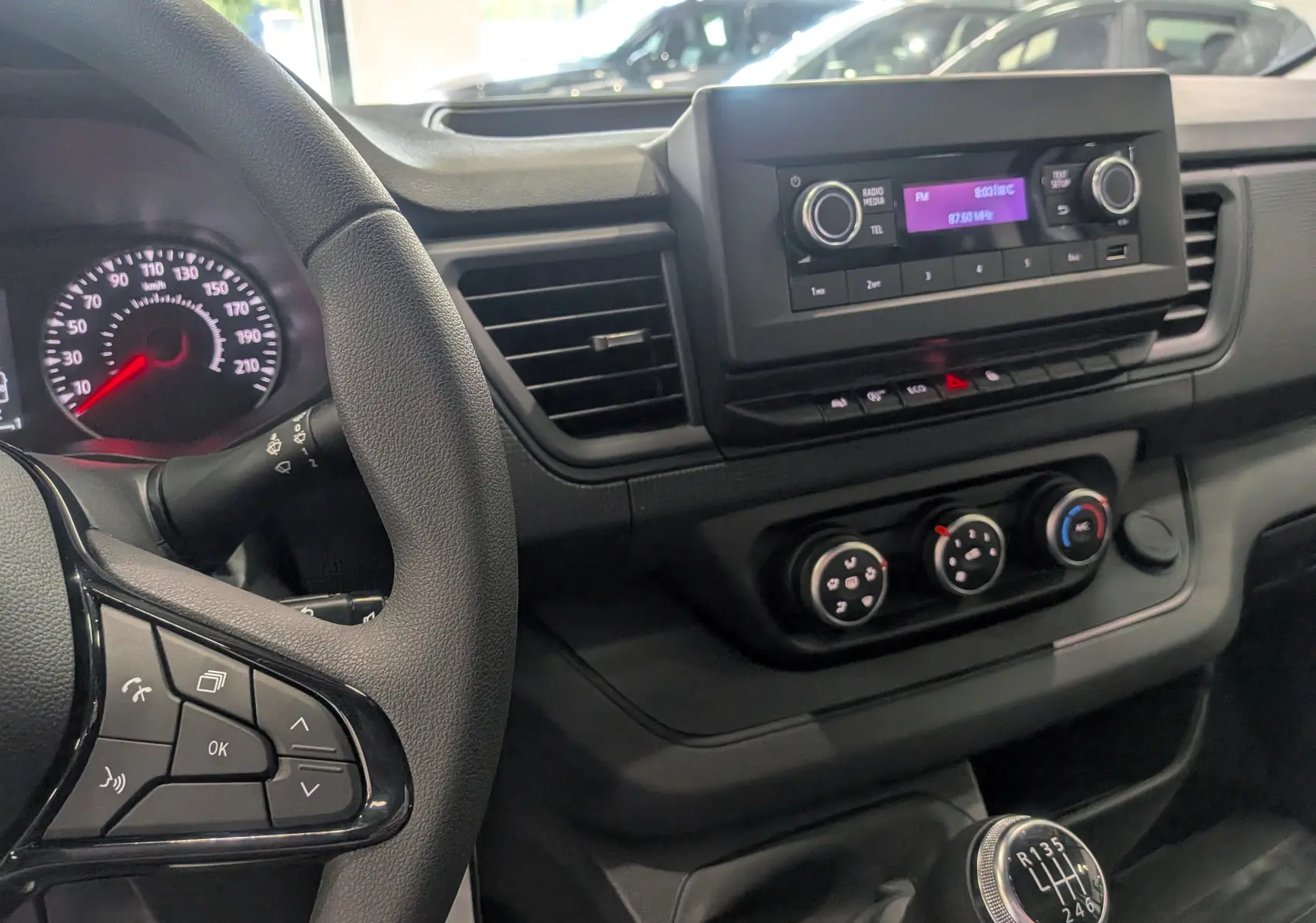 Intérieur du Renault Trafic cabine approfondie 2023, vue du tableau de bord côté conducteur avec volant et commandes manuelles.