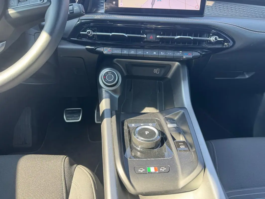 Vue rapprochée de la console centrale de l'Alfa Romeo Tonale 2025, avec sélecteur de boîte rotatif et finitions noires.