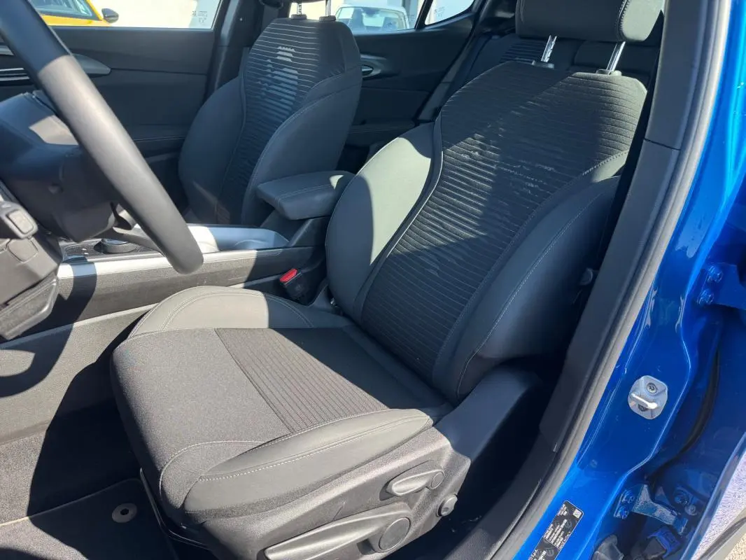 Vue intérieure côté conducteur de l'Alfa Romeo Tonale bleu foncé, montrant le siège sport et l'accoudoir central.