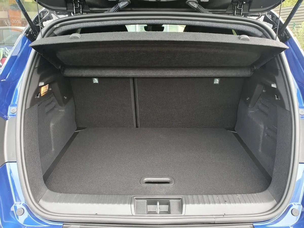 Coffre ouvert vu de l'arrière du Renault Captur Bleu Iron, montrant un espace de rangement propre et spacieux.