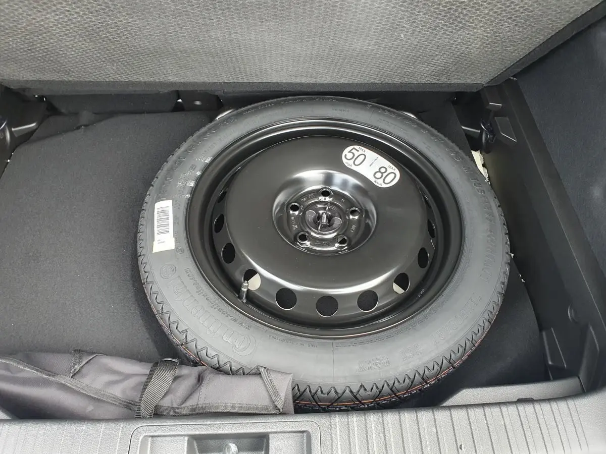 Roue de secours temporaire noire dans le coffre du Renault Captur 2026, vue plongeante sur le pneu.