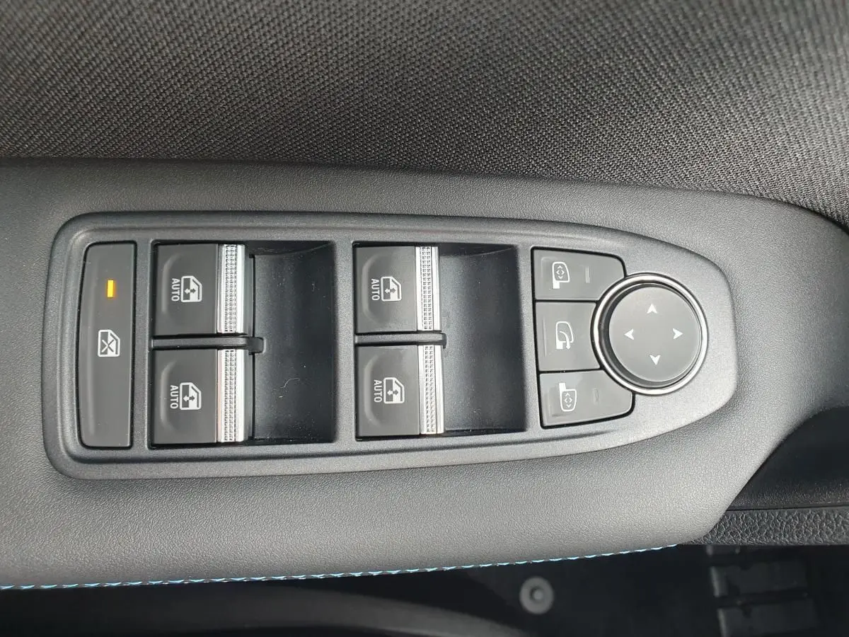 Panneau de commandes des vitres et rétroviseurs sur la portière côté conducteur du Renault Captur bleu Iron 2026.