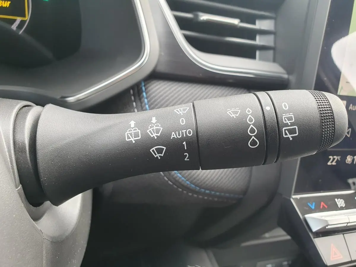 Gros plan sur la commande d’essuie-glace du Renault Captur 2026, intérieur noir avec surpiqûres bleues.