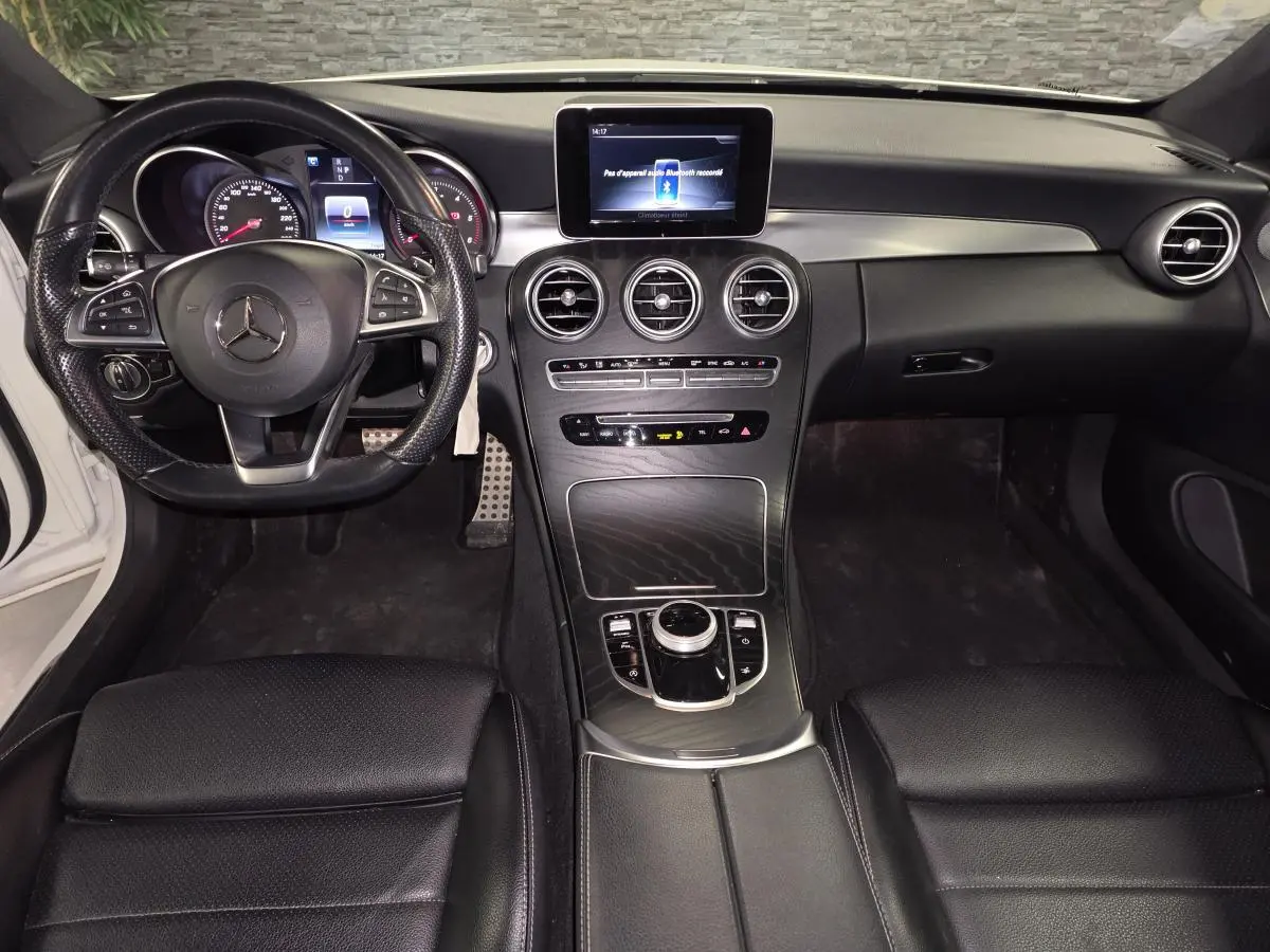 Intérieur noir de Mercedes Classe C Coupé 2017, vue frontale sur tableau de bord et volant multifonction AMG.