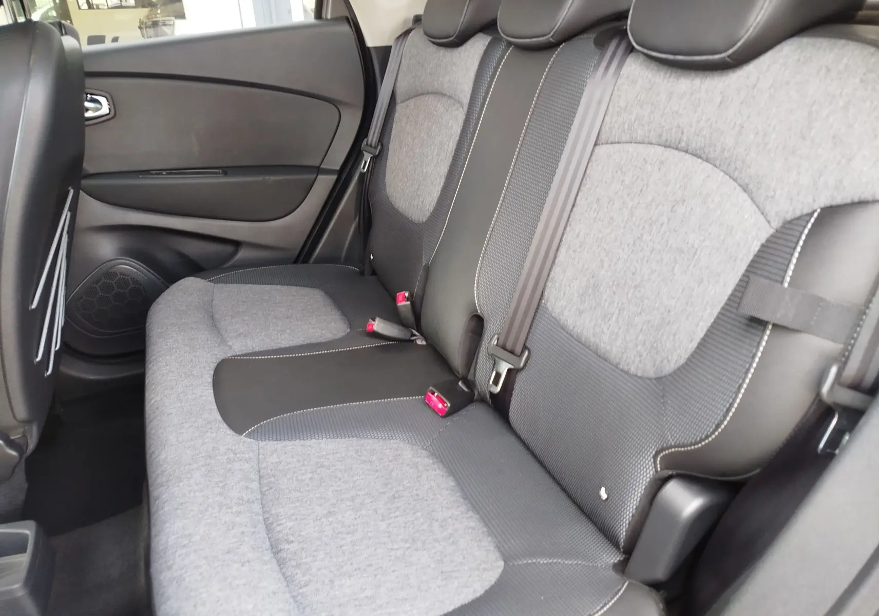 Vue latérale droite de la banquette arrière gris clair et noir du Renault Captur 2018, avec ceintures et appuie-têtes visibles.