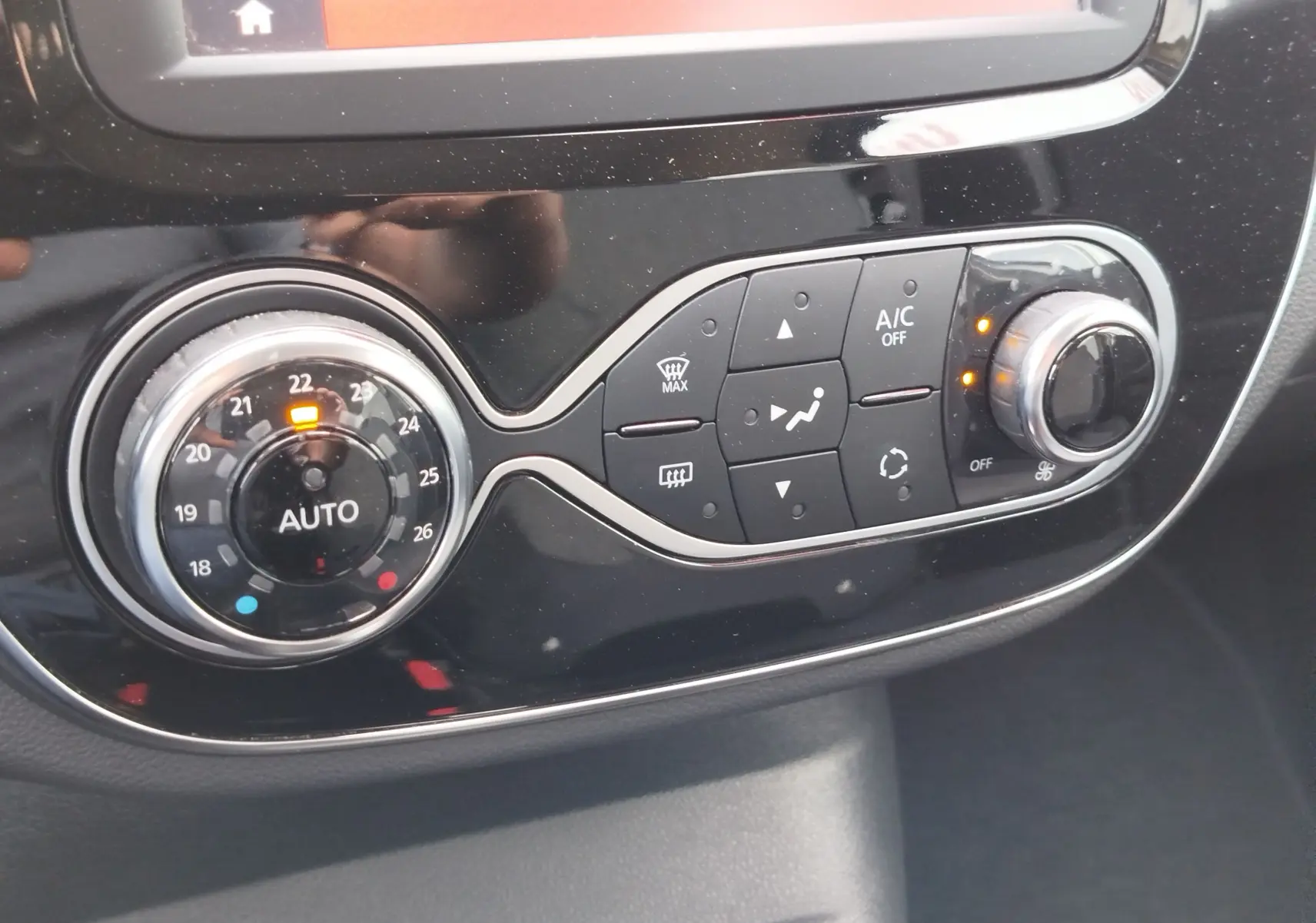 Gros plan sur la commande de climatisation automatique du Renault Captur 2018, avec réglage à 22°C et boutons lumineux.