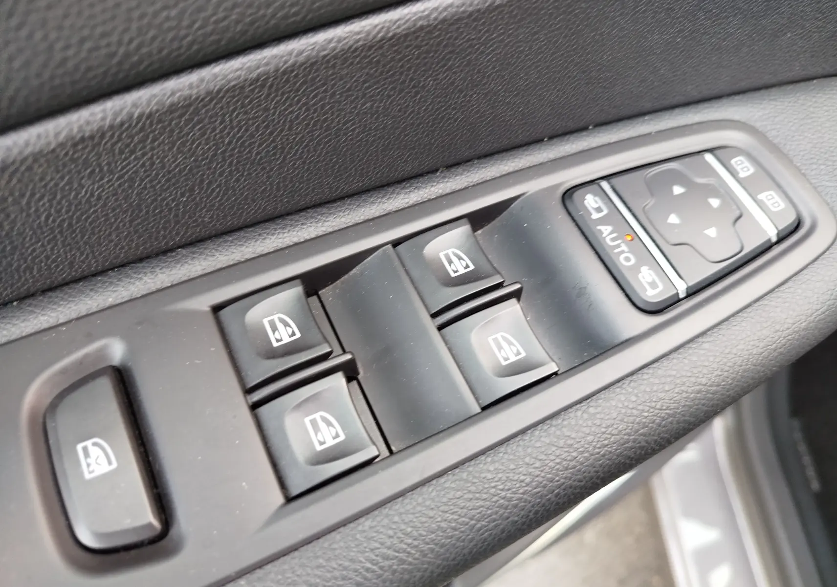 Gros plan sur les commandes de lève-vitres et réglages des rétroviseurs côté conducteur du Renault Captur Gris Cassiopée.