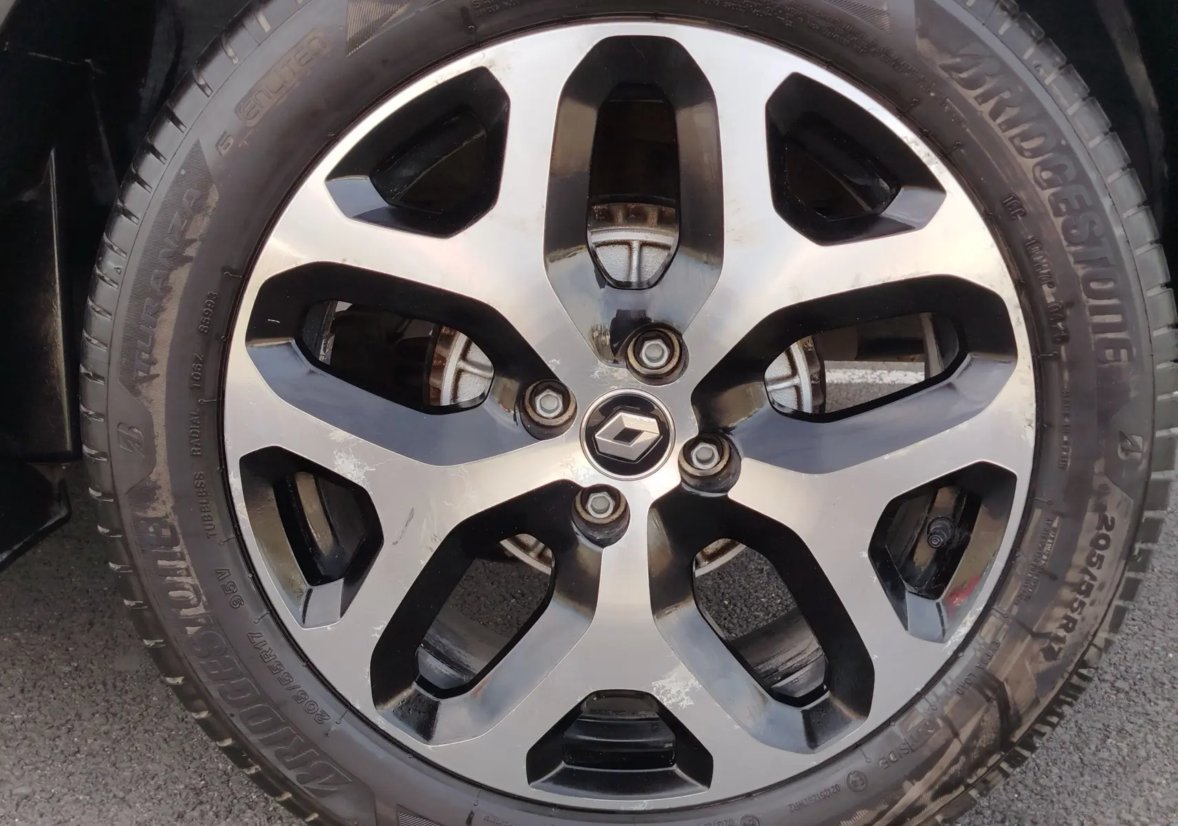 Gros plan sur la jante alliage bicolore noire et argentée du Renault Captur Gris Cassiopée de 2018, avec logo central Renault.