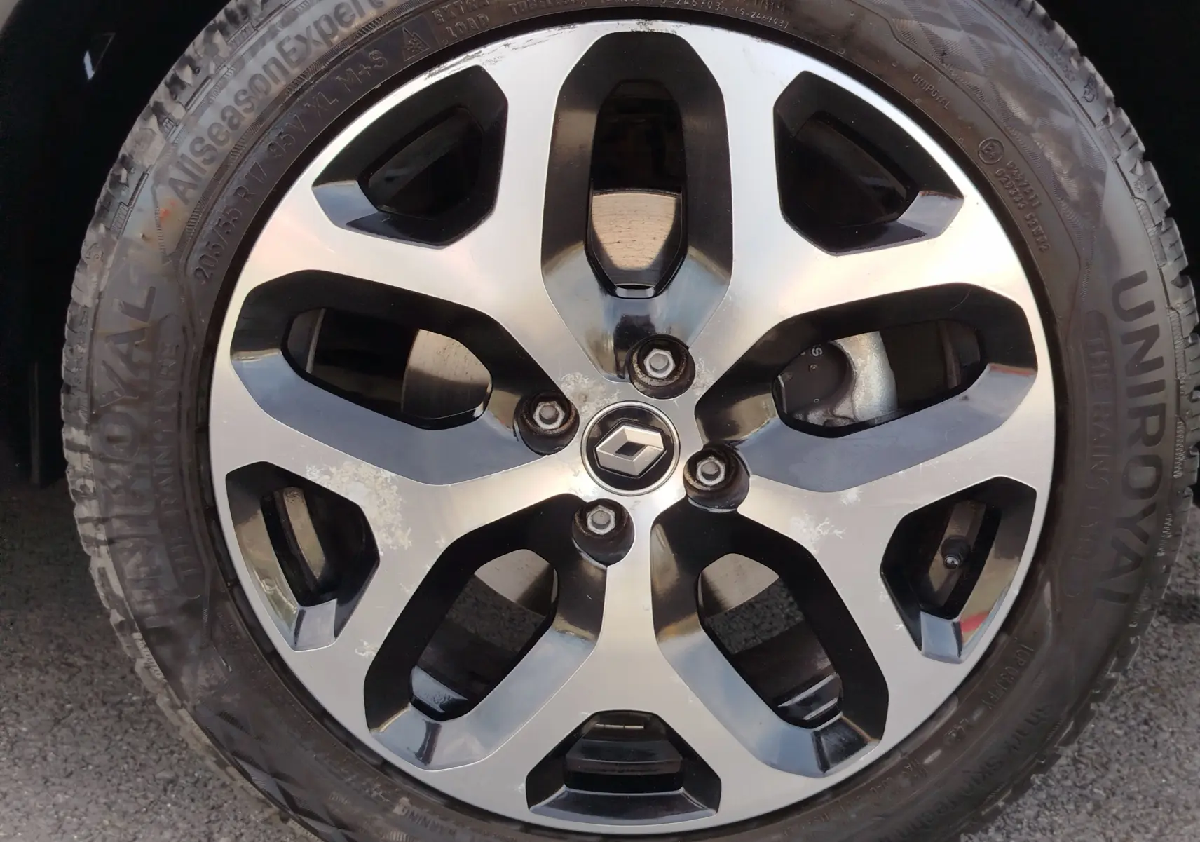 Gros plan sur la jante alliage bicolore avec logo Renault, roue montée sur Renault Captur Gris Cassiopée 2018.