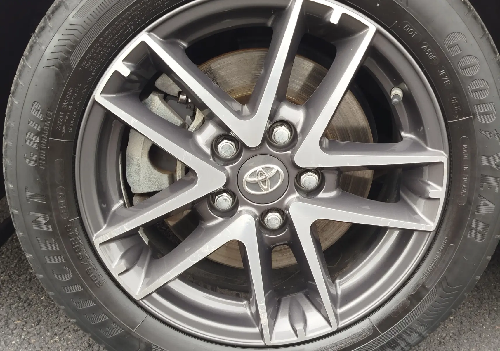 Gros plan sur la jante alliage gris foncé de la Toyota Auris HSD 136h 2015 avec logo Toyota au centre.
