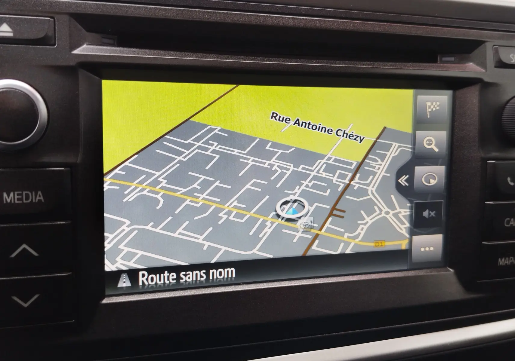 Écran de navigation GPS intégré dans une Toyota Auris HSD 136h gris aluminium, affichant une carte avec rue Antoine Chézy.