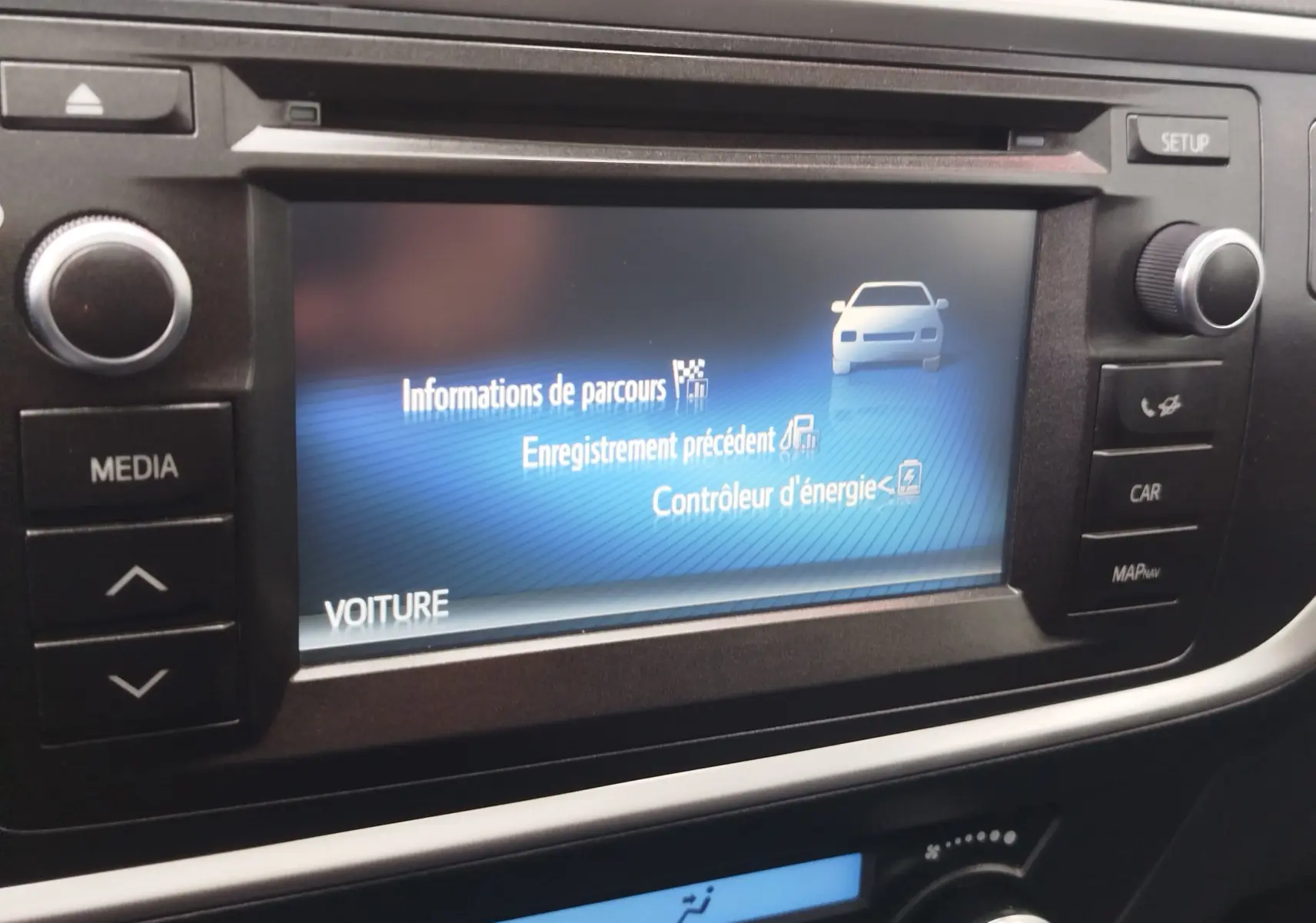 Écran central de la Toyota Auris HSD 136h 2015 affichant les informations de parcours et contrôle d'énergie.