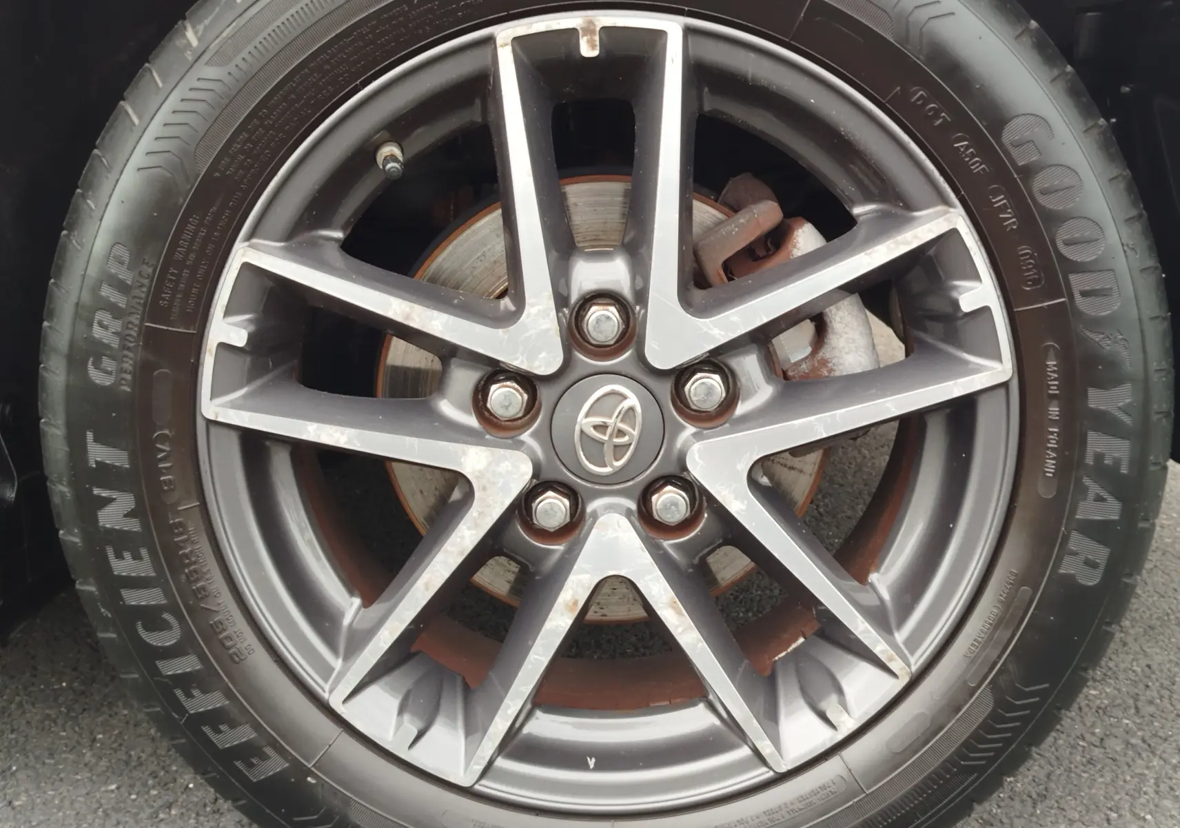 Gros plan sur la jante alliage gris foncé à 5 doubles branches de la Toyota Auris HSD 136h, pneu Goodyear visible.