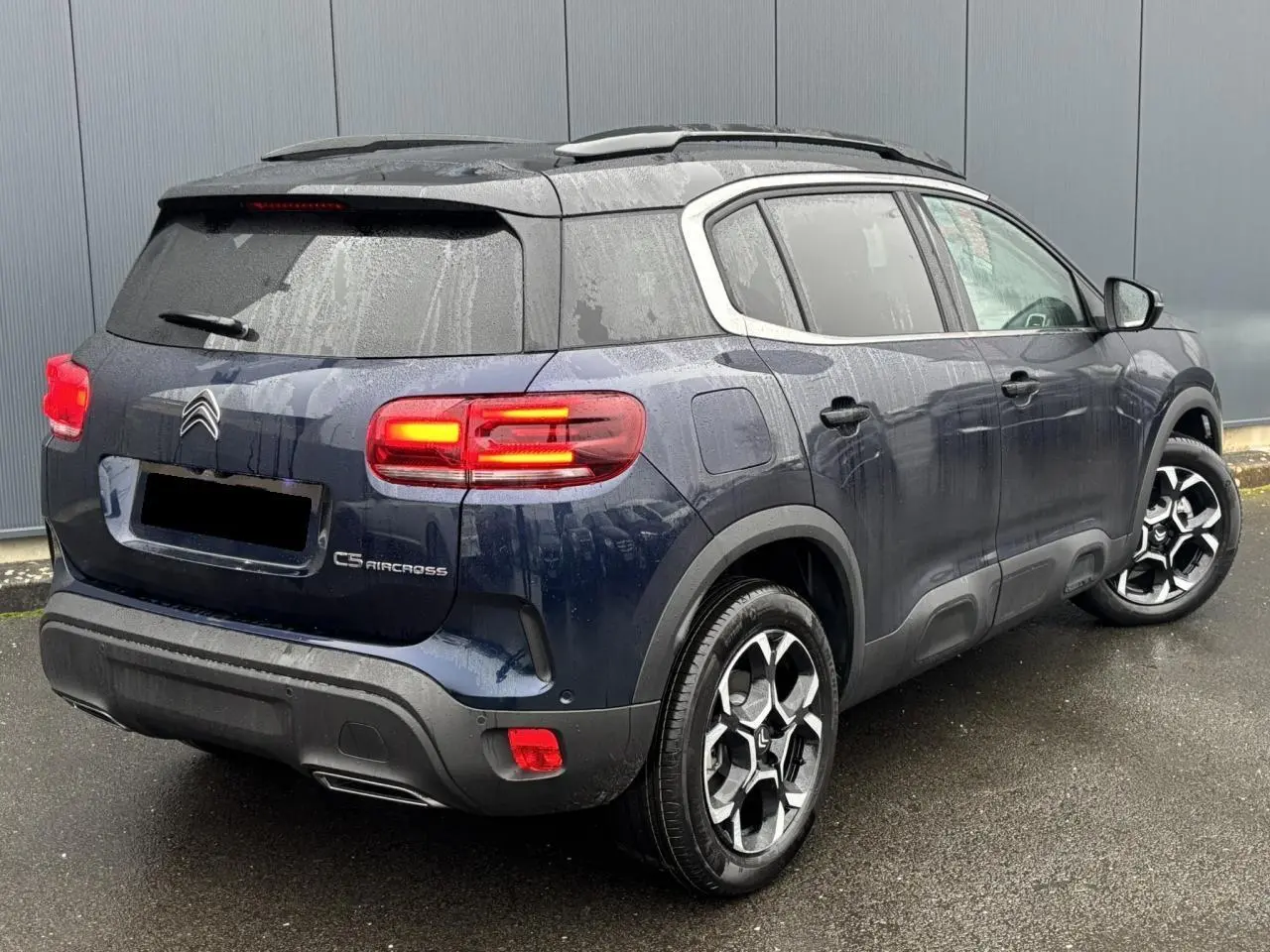 Vue 3/4 arrière droite d'un Citroën C5 Aircross Bleu Eclipse avec feux arrière LED et jantes alliage bi-ton.