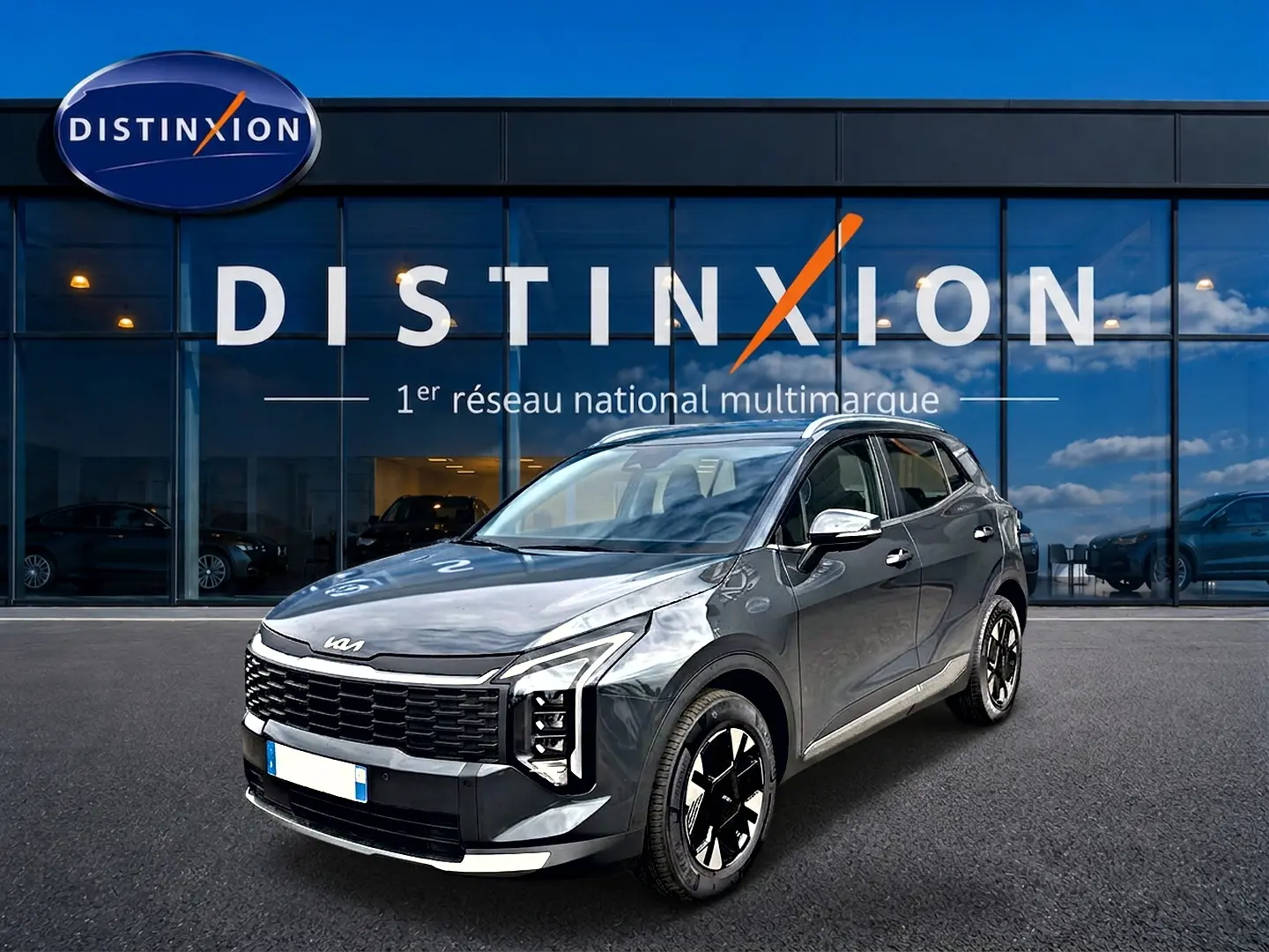KIA Sportage 1.6 hybride gris eclipse en 3/4 avant droit, avec calandre noire et jantes alu bicolores.