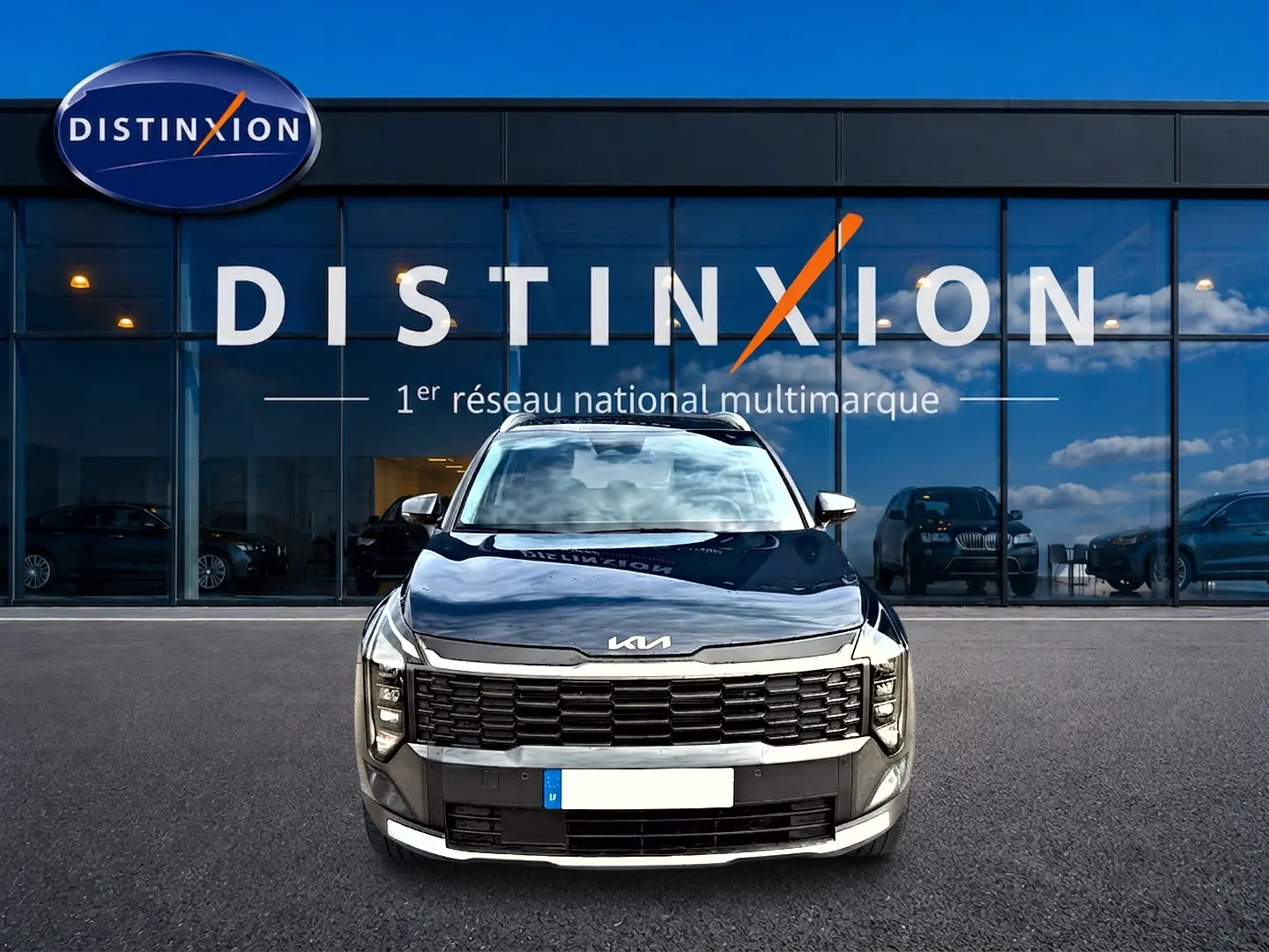 Vue frontale du KIA SPORTAGE 1.6 hybride gris eclipse, avec calandre noire et logo KIA sur capot.