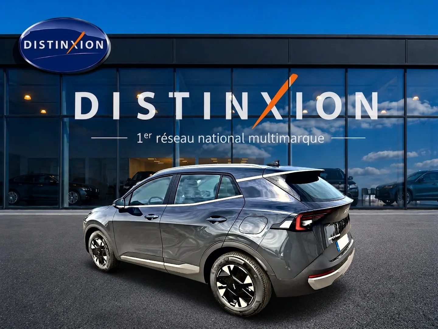 KIA Sportage 1.6 hybride gris eclipse en 3/4 arrière droit, avec jantes alu et feux arrière LED distinctifs.