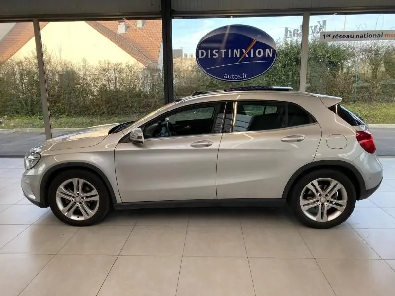 Profil côté gauche d'un Mercedes GLA 200 Sensation gris montagne, présenté en intérieur avec jantes alliage visibles.