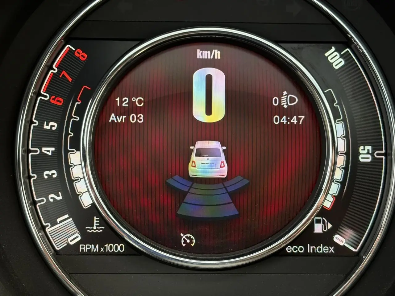 Affichage numérique central du combiné de bord de la Fiat 500 Hybrid 2024, montrant la vitesse à 0 km/h et le radar de recul actif.