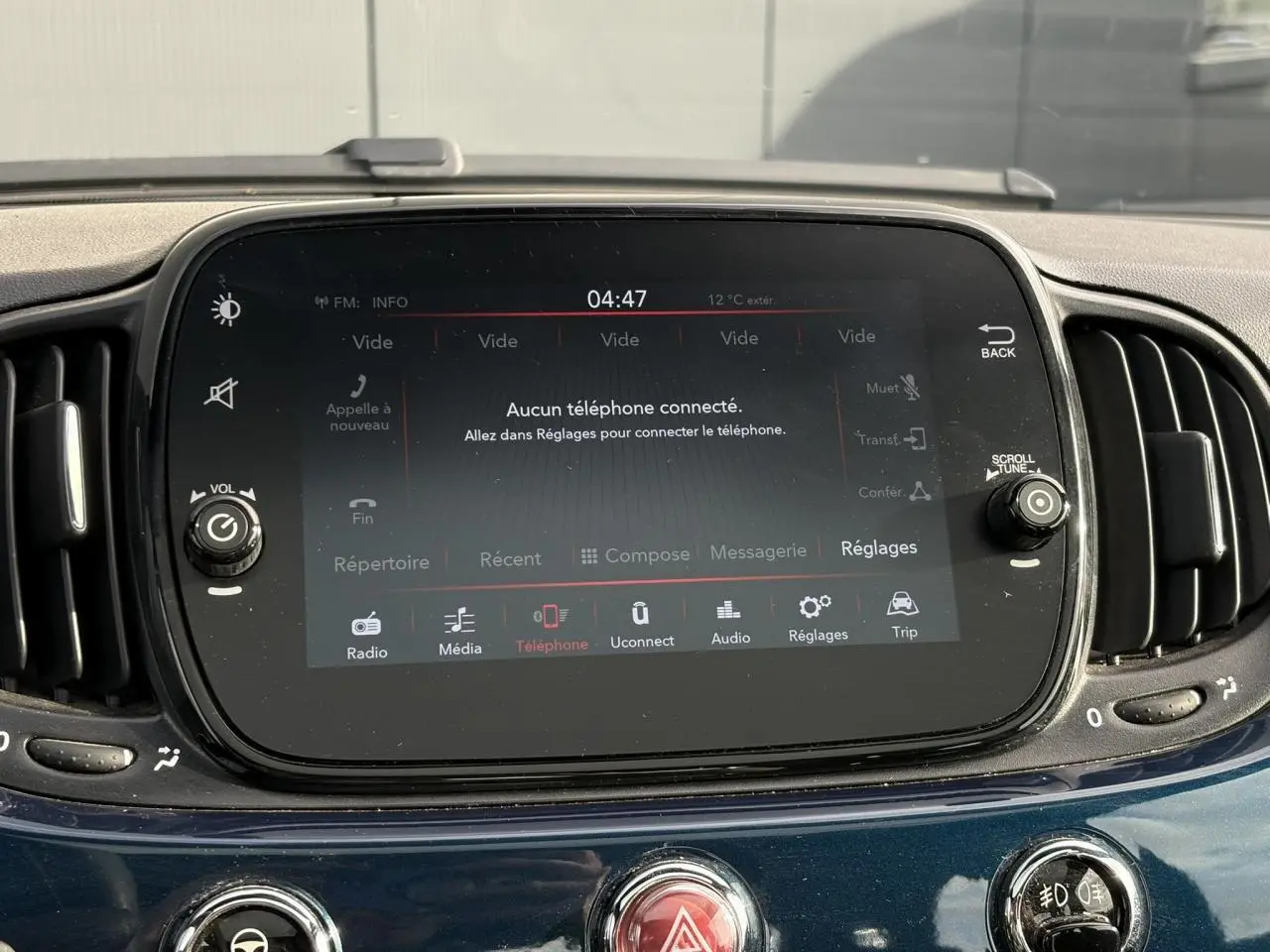 Gros plan sur l’écran tactile central du tableau de bord d’une FIAT 500 Hybrid bleu Dipinto, affichage multimédia.
