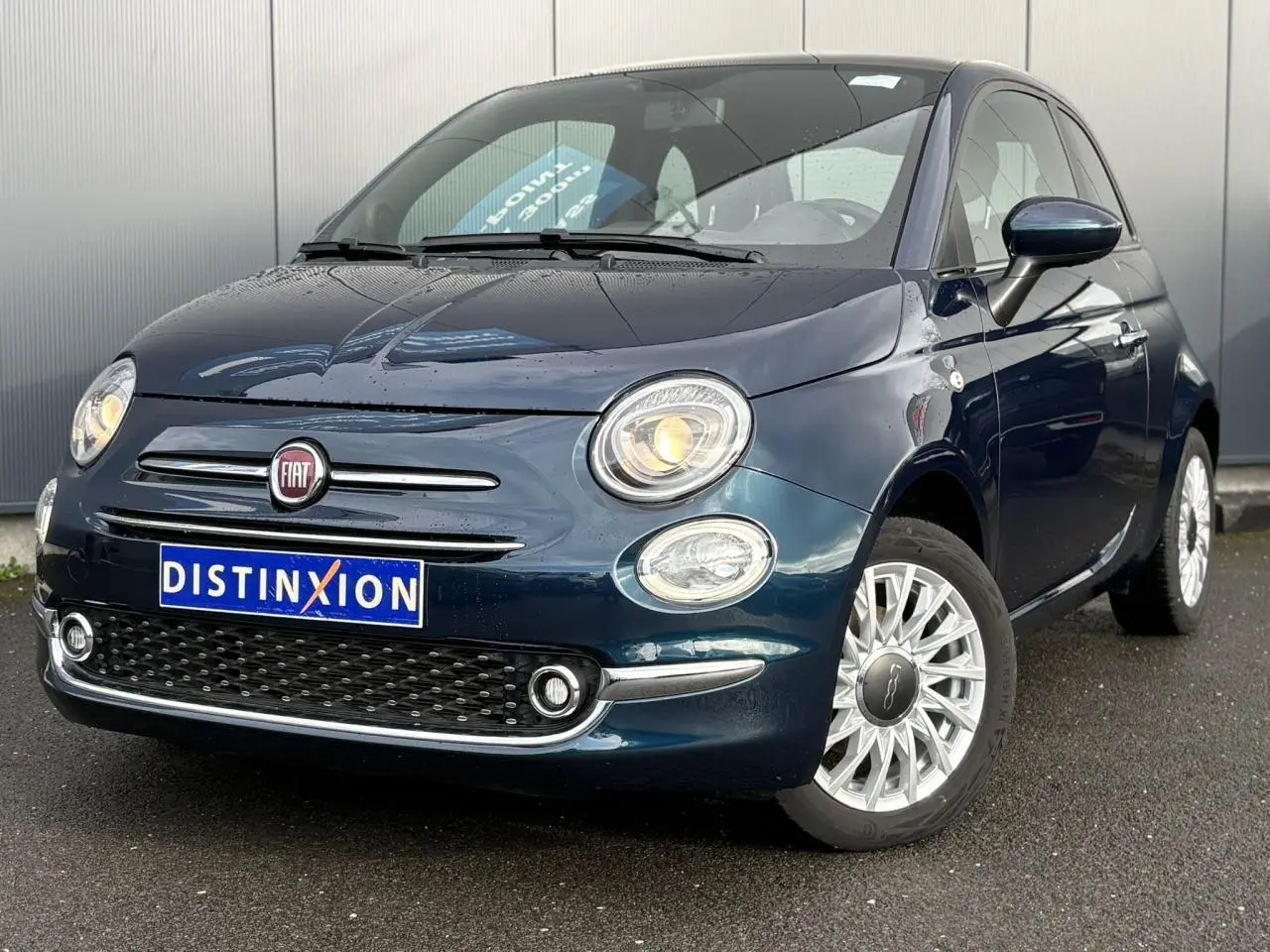 Vue 3/4 avant droite d'une Fiat 500 Hybrid 70 bleu Dipinto avec jantes alliage 15 pouces et toit panoramique.