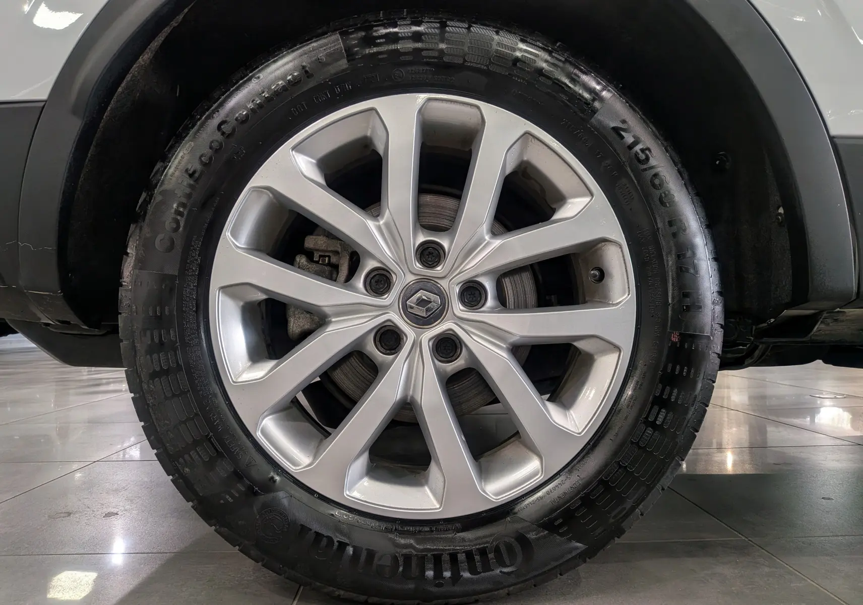 Gros plan sur la roue avant droite du Renault Kadjar Blanc Glacier, mettant en valeur la jante alliage et le pneu Continental.