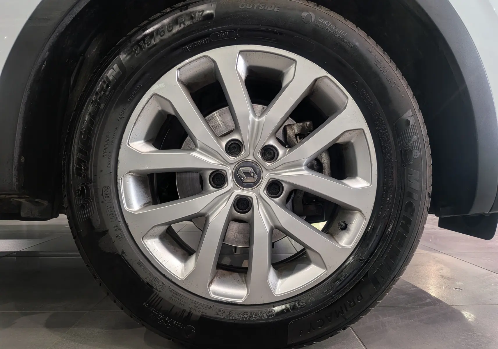 Gros plan sur la roue avant droite du Renault Kadjar blanc Glacier, mettant en valeur la jante alliage et le pneu Michelin.