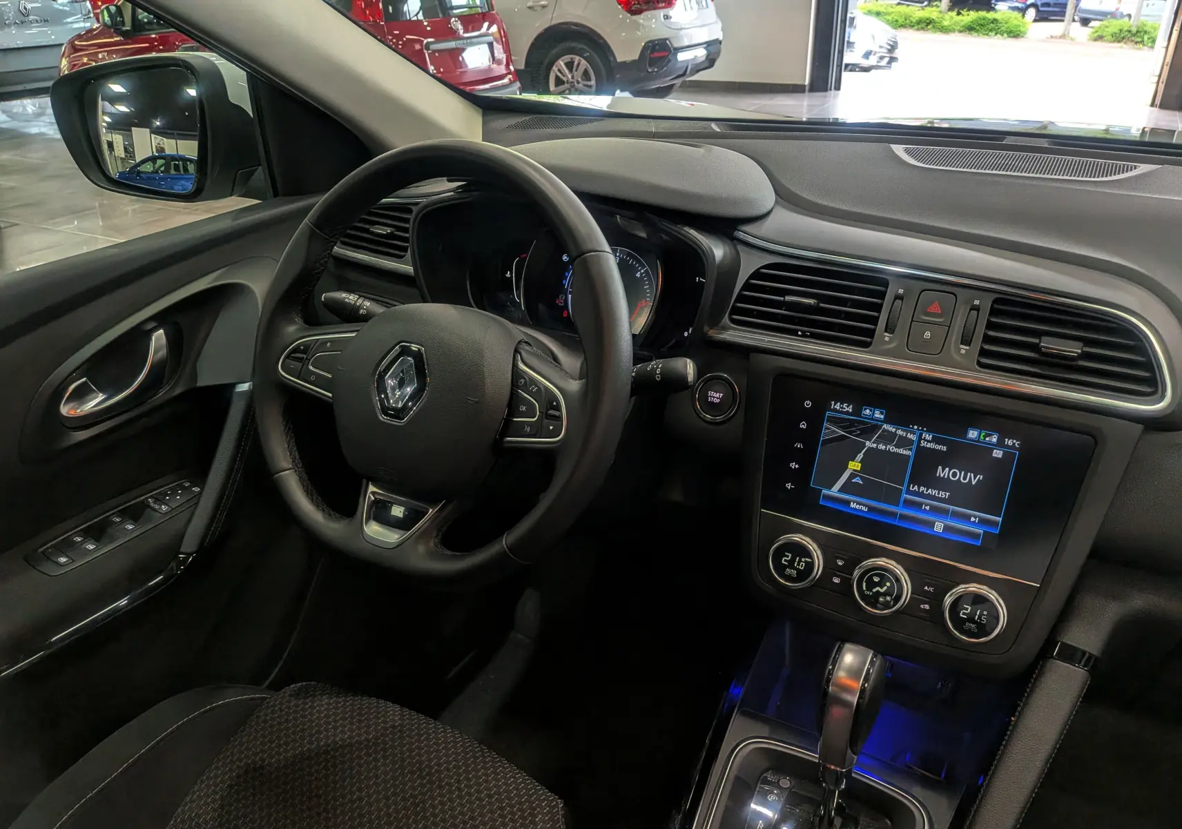 Vue intérieure côté conducteur du Renault Kadjar 2021, tableau de bord noir avec écran tactile et volant multifonction.