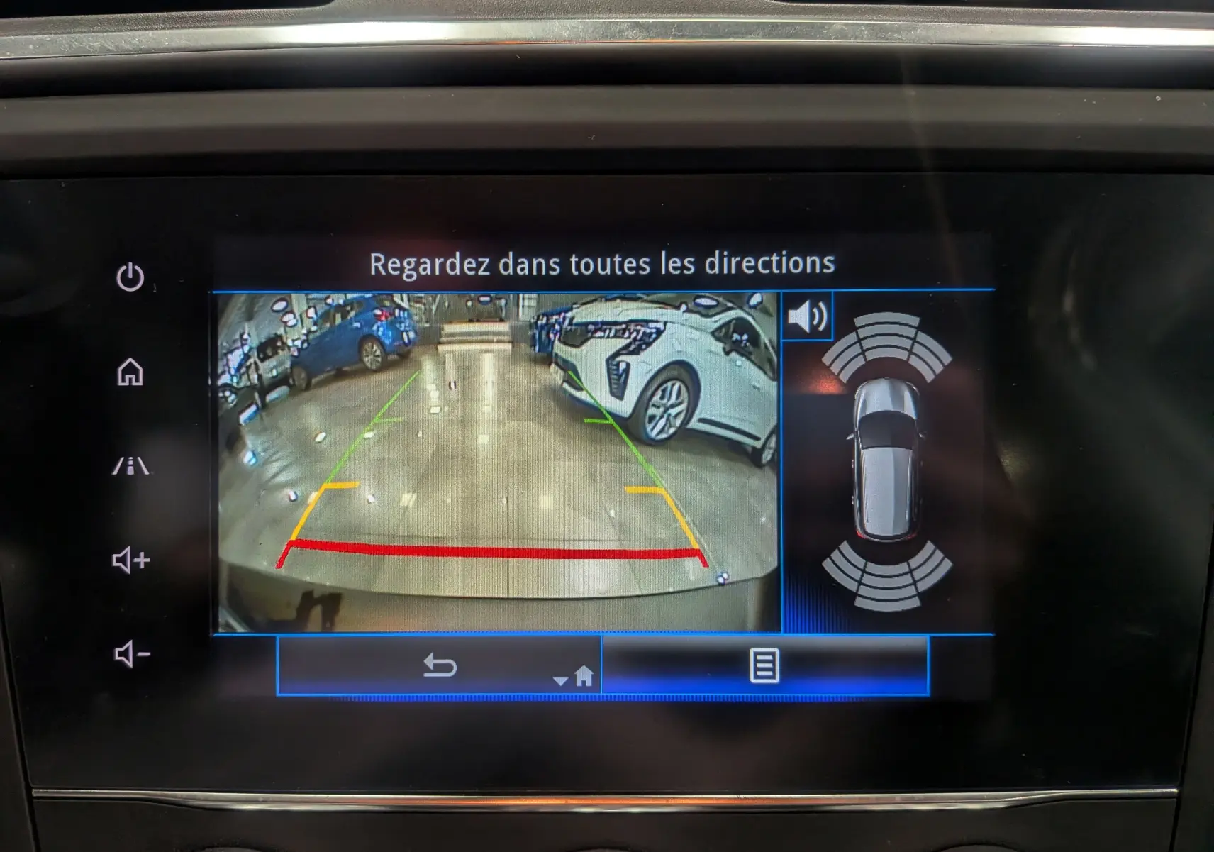 Écran de caméra de recul du Renault Kadjar blanc glacier, affichant l'arrière et les capteurs de stationnement actifs.