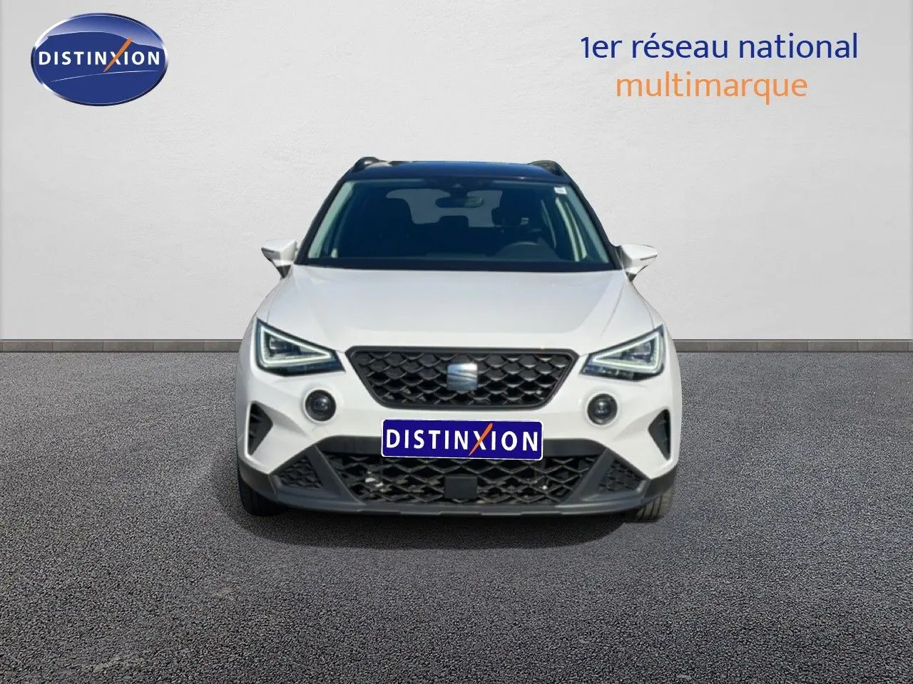 Vue frontale d'un SEAT Arona blanc avec toit gris, calandre noire et feux LED distinctifs, 2025.