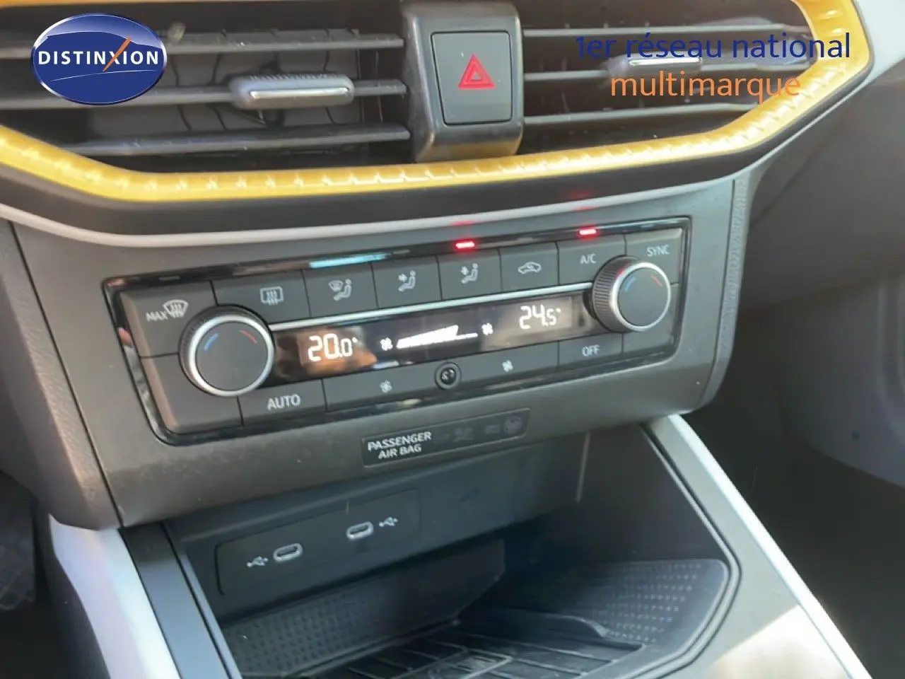Détail de la console centrale du SEAT Arona 2025, montrant la climatisation bi-zone avec affichage digital et bordure jaune.