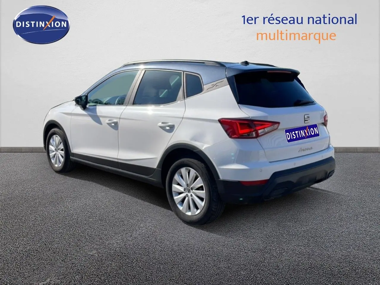 Vue 3/4 arrière droite d'un SEAT Arona blanc avec toit gris, mettant en valeur ses lignes modernes et ses feux arrière LED.