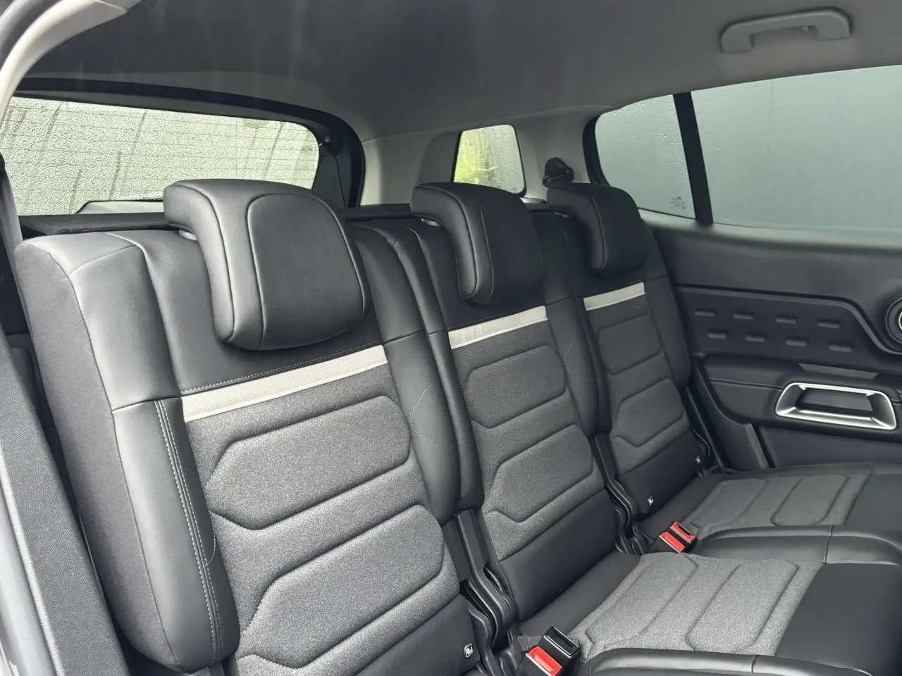 Vue latérale droite des trois sièges arrière indépendants gris et noirs du Citroën C5 Aircross 2025, avec appuis-tête réglables.
