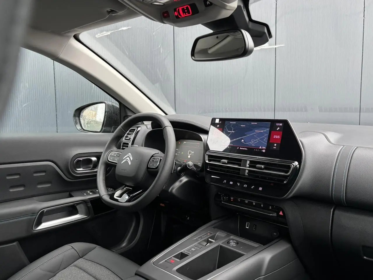 Vue intérieure côté conducteur du Citroën C5 Aircross 2025, tableau de bord noir avec écran tactile et volant multifonction.