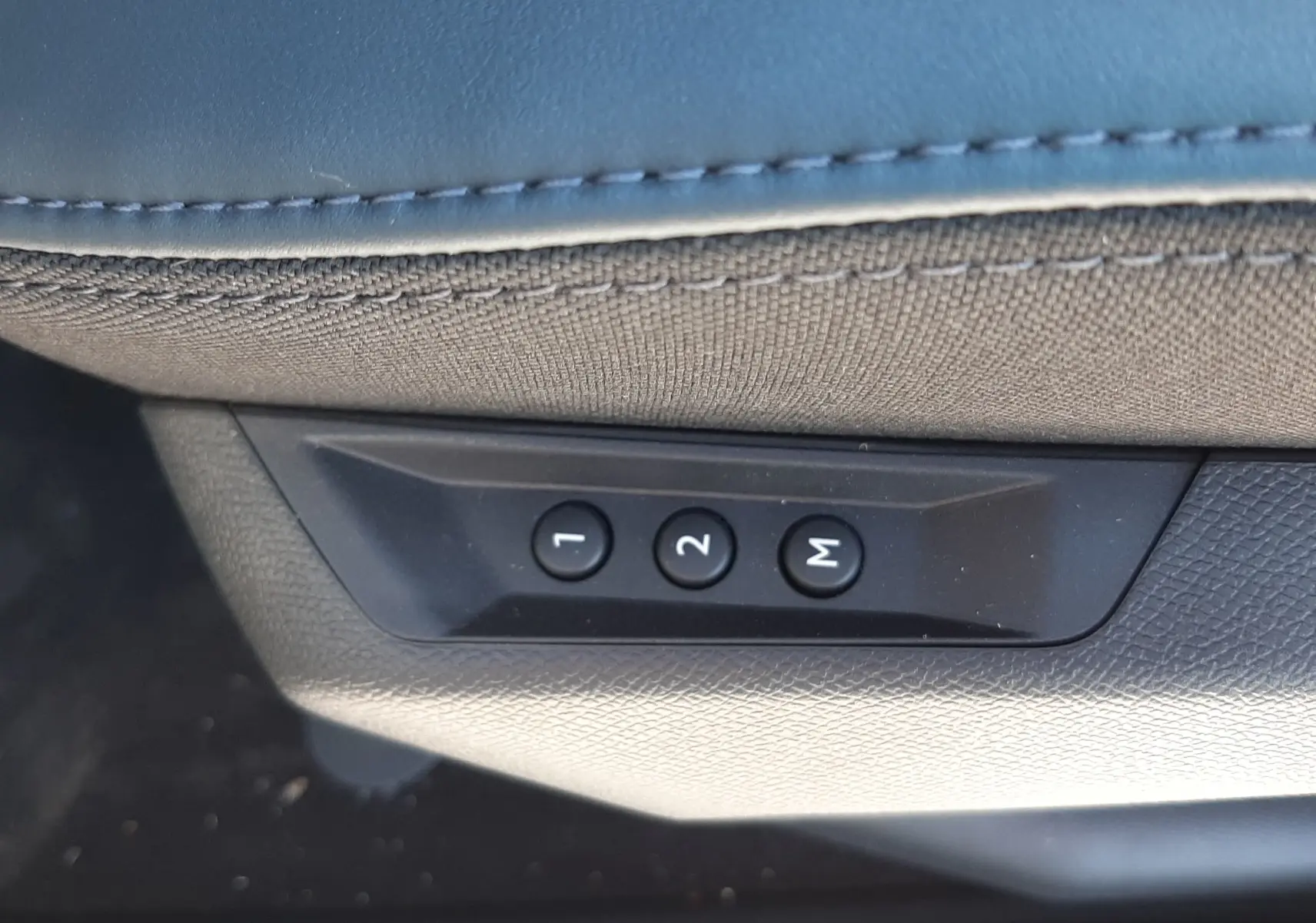 Gros plan sur les boutons de réglage mémoire des sièges noirs dans une Citroën C5 Aircross hybride 2026.