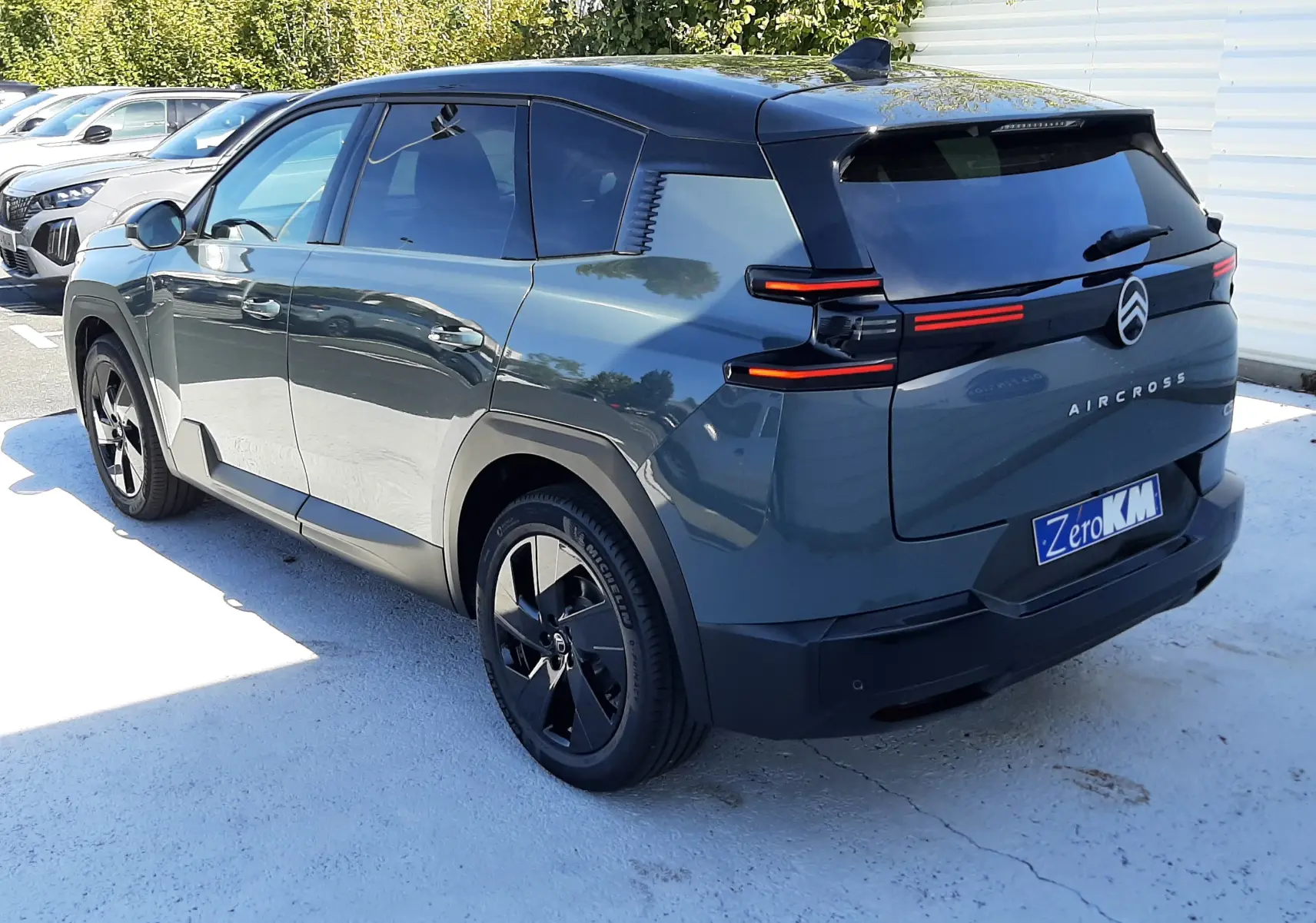 Vue 3/4 arrière droite du Citroën C5 Aircross vert Astoria avec toit noir et feux arrière LED distinctifs.