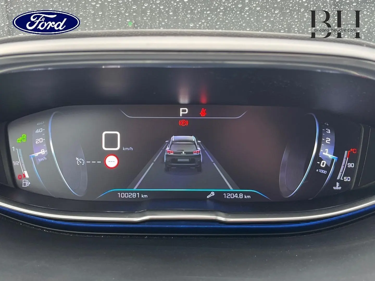 Tableau de bord numérique du Peugeot 5008 2018 affichant la vitesse, compte-tours et un véhicule noir vu de dos au centre.