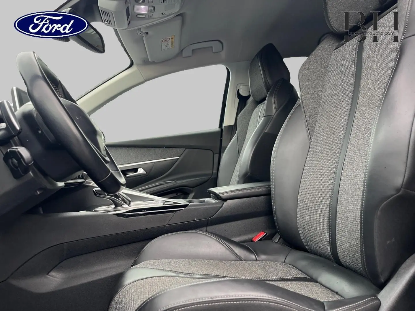 Vue intérieure côté conducteur du Peugeot 5008 2018, sièges tissu et cuir gris avec console centrale noire.